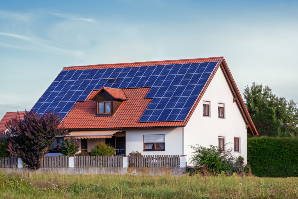 Gibt es klimaneutrale Alternativen zur Wärmepumpe? Hausbau Helden Modernes Haus mit Photovoltaik-Solarzellen auf dem Dach zur alternativen Energiegewinnung
