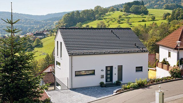 Gute Aussichten: Haus am Hang - Ein Haus mit einem Berg im Hintergrund - Fertighaus