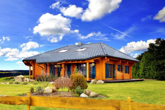 Haus Alaska - Ein großes Backsteingebäude mit einer Rasenfläche - Holzhaus
