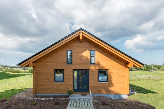 Musterhaus Wismarbucht - Ein großes Backsteingebäude mit Gras vor einem Haus - Haus