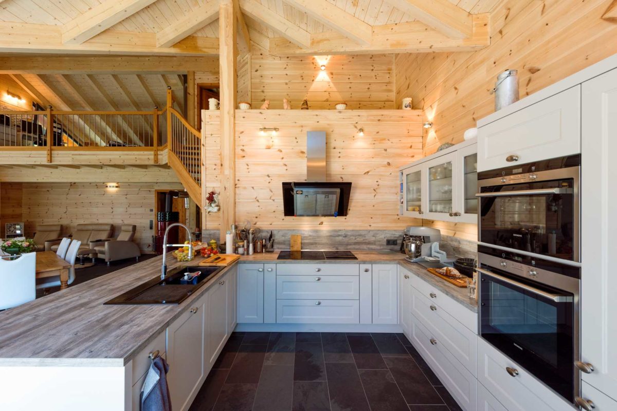 Haus Elzruhe - Eine moderne Küche mit Edelstahlgeräten und Holzschränken - Fullwood Wohnblockhaus