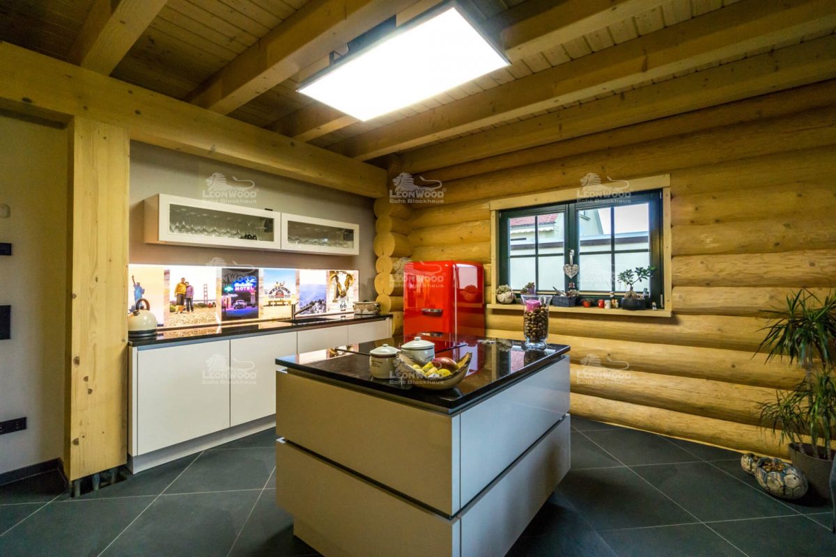 Haus Canada - Eine Küche mit einem Tisch in einem Raum - LéonWood Holz-Blockhaus GmbH