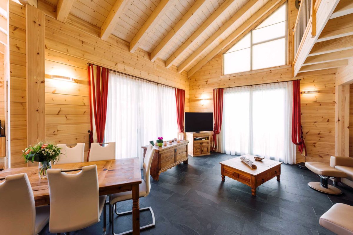 Haus Elzruhe - Ein Wohnzimmer mit Möbeln und einem großen Fenster - Holzhaus