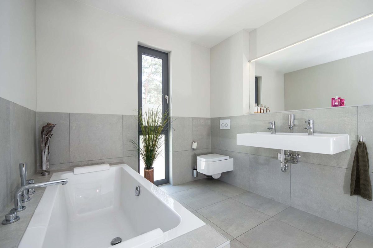 Haus Cornelius - Eine große weiße Wanne neben einem Waschbecken und einem Spiegel - Haus
