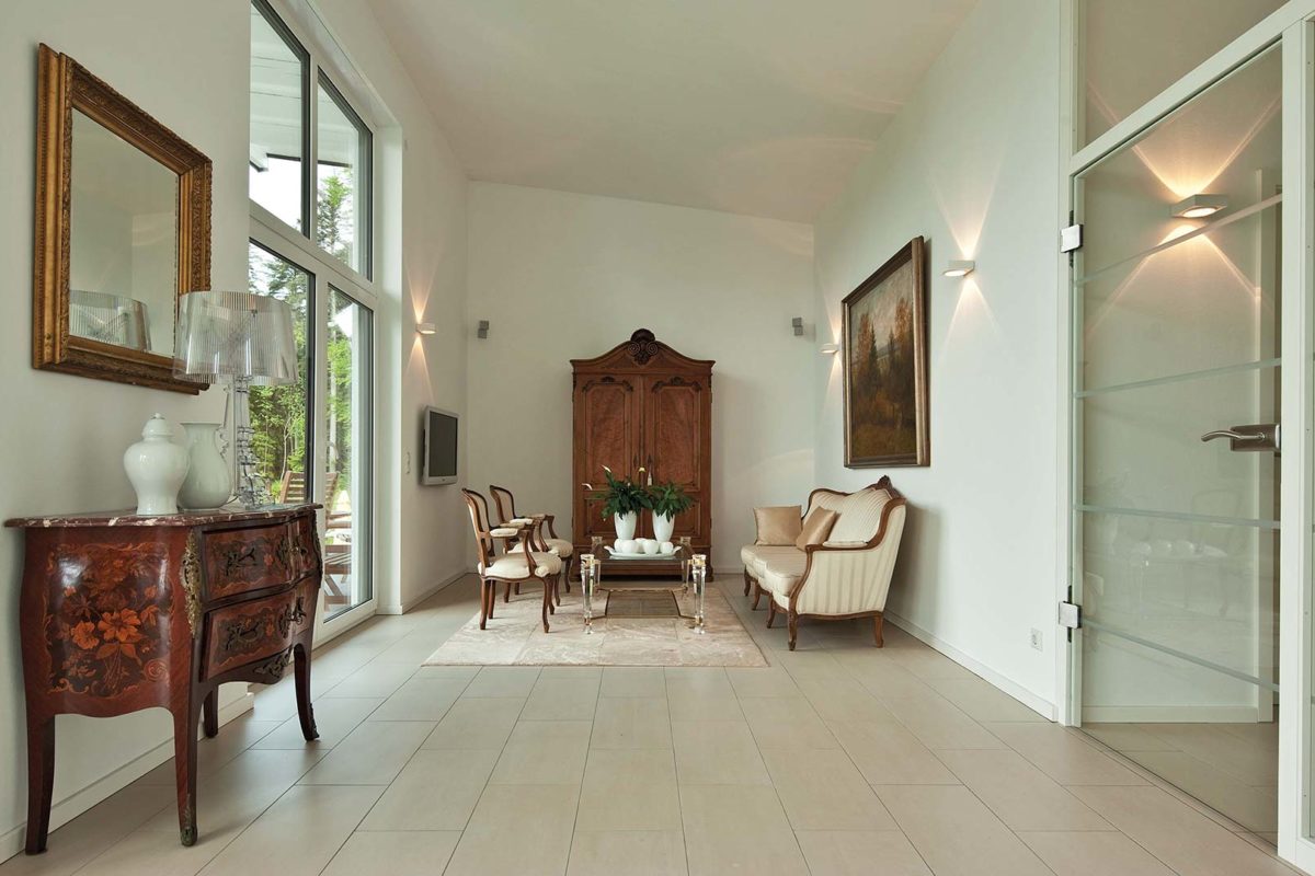 Haus Kempf - Ein Wohnzimmer mit Möbeln und einem großen Fenster - Interior Design Services