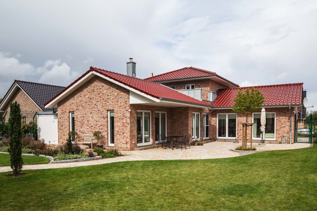 Haus Pohl - Ein großes Backsteingebäude mit Gras vor einem Haus - Haus