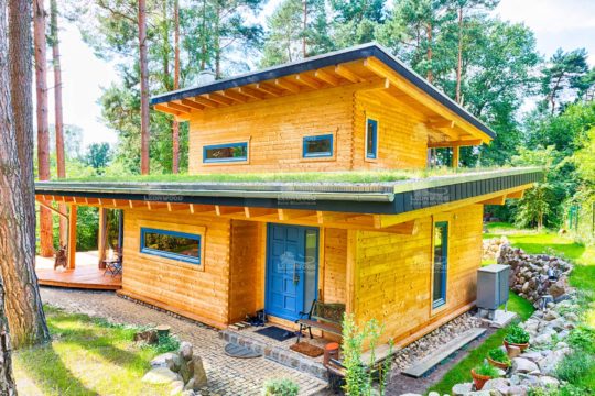 Blockhaus Kalevala - Ein gelbes haus im hintergrund - Holzhaus