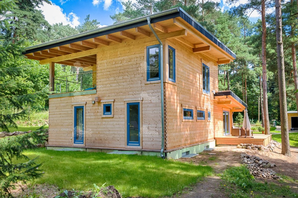 Blockhaus Kalevala - Ein großes Backsteingebäude mit Gras vor einem Haus - Blockhaus