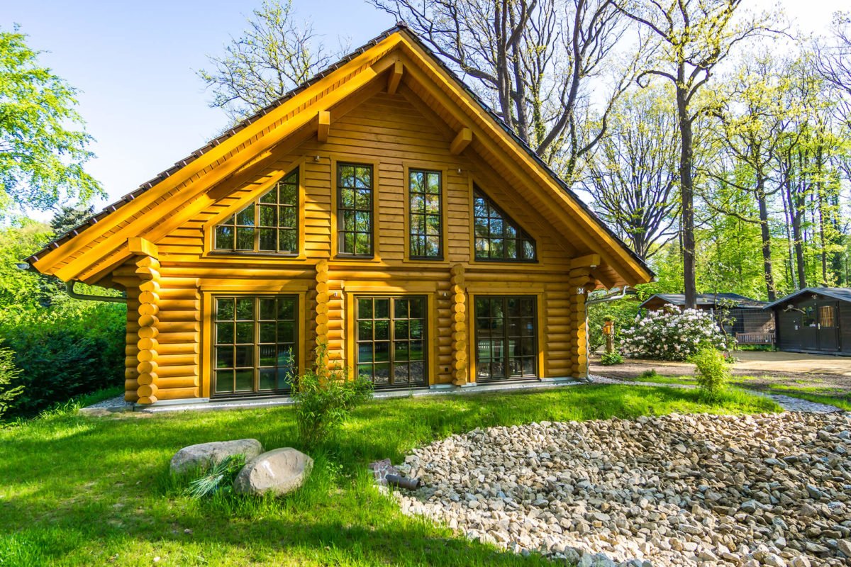 Nordwind - Ein großes Backsteingebäude mit Gras vor einem Haus - Blockhaus