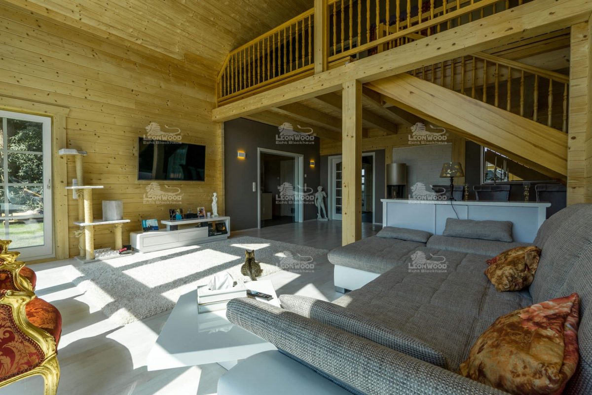 Haus Ontario - Ein Schlafzimmer mit Kamin und großem Fenster - LéonWood Holz-Blockhaus GmbH
