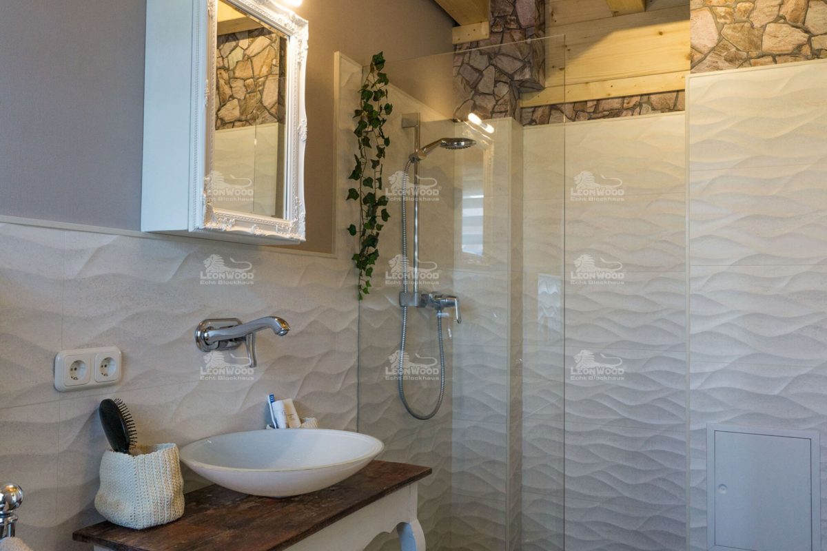 Haus Ontario - Eine weiße Spüle sitzt unter einem Spiegel - Holzhaus