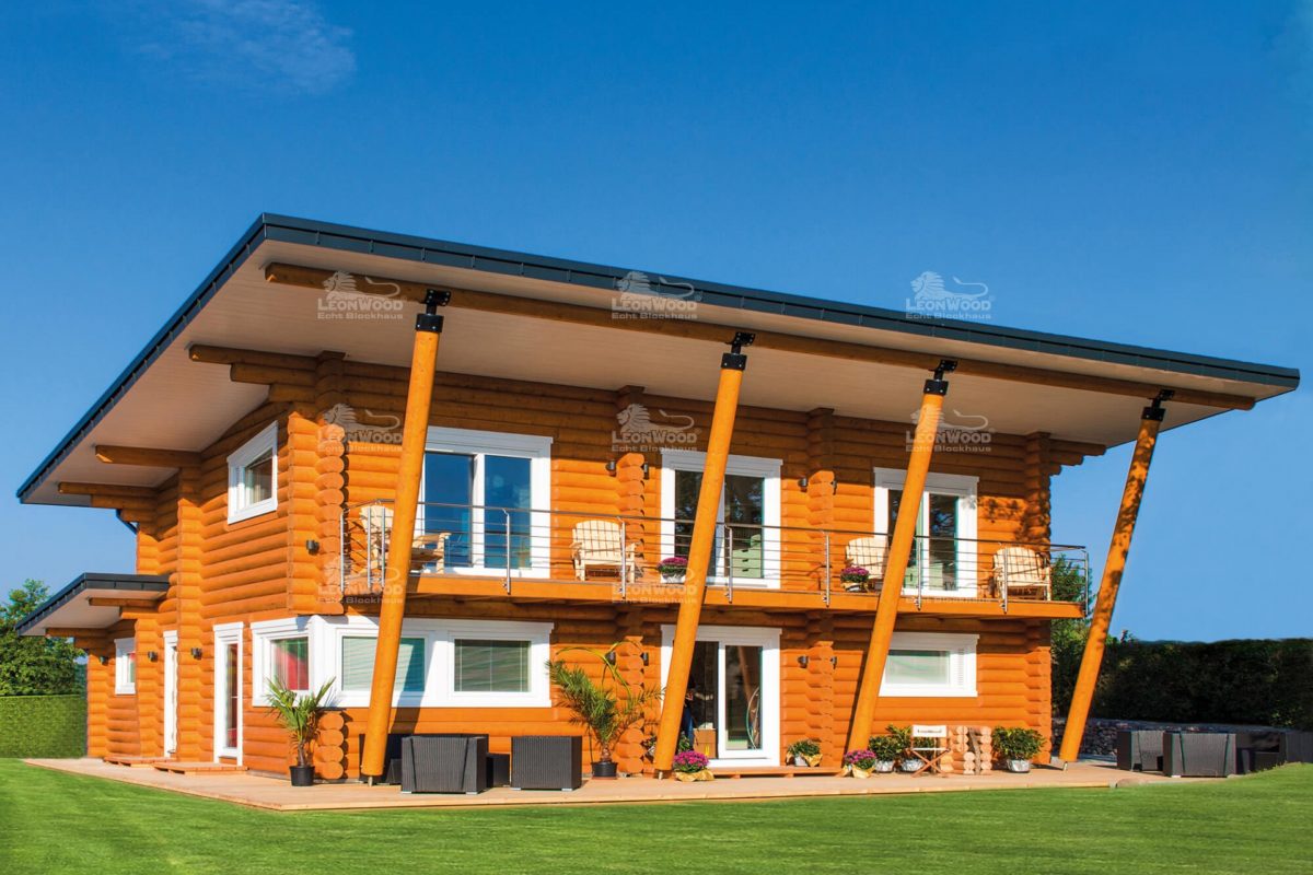 Musterhaus Mikado - Ein großes Backsteingebäude mit Gras vor einem Haus - Holzhaus