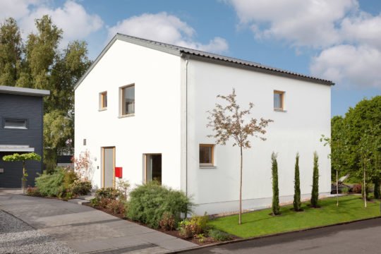 Musterhaus Mono - Ein Haus mit Bäumen im Hintergrund - SchwörerHaus KG Musterhaus Mannheim