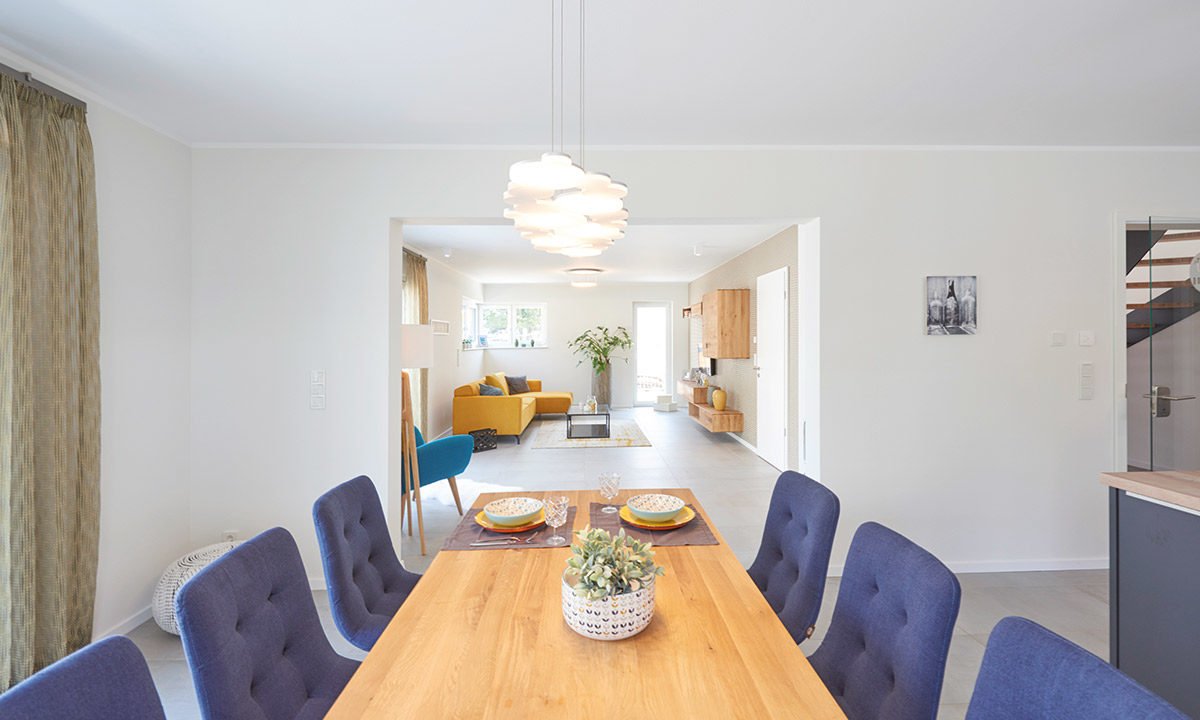Musterhaus Stuttgart - Ein Wohnzimmer mit Möbeln und einem Tisch - FINGERHUT Haus