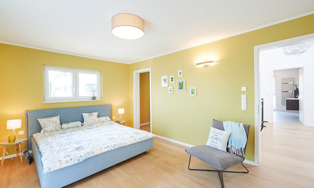 Musterhaus Stuttgart - Ein Schlafzimmer mit einem Bett und einem Spiegel in einem Raum - FINGERHUT Haus