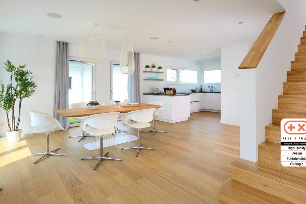 Musterhaus Life - Ein Wohnzimmer mit Möbeln und einem großen Fenster - Fertighaus Weiss