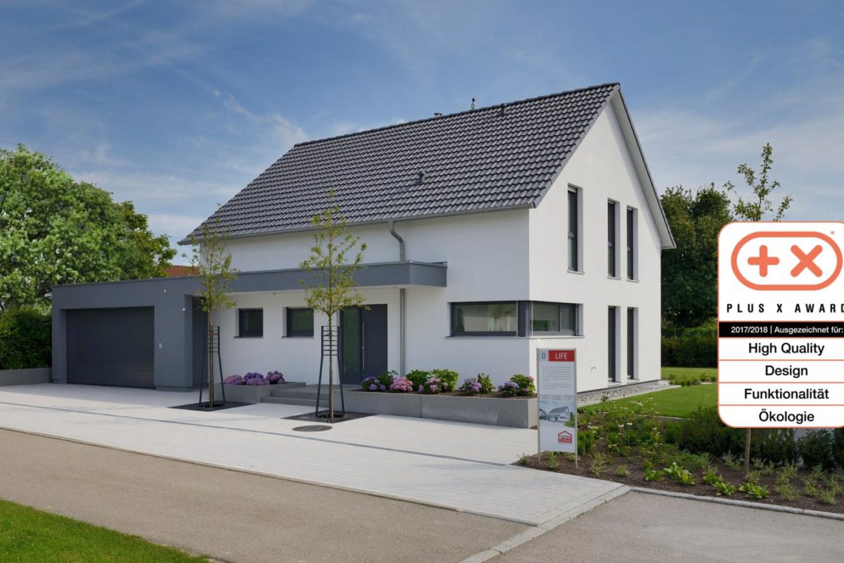 Musterhaus Life - Ein Haus mit einem Schild am Straßenrand - Fertighaus Weiss