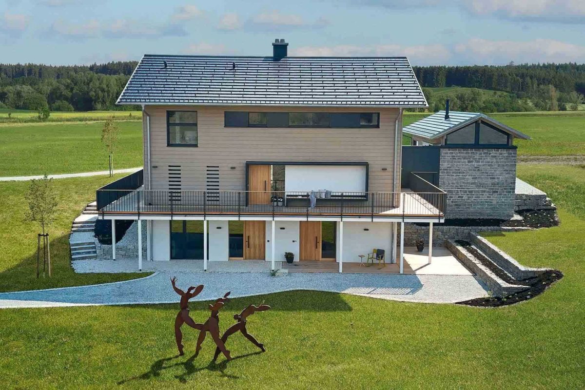 Musterhaus Heimat 4.0 - Eine große Wiese vor einem Gebäude - Holzhaus