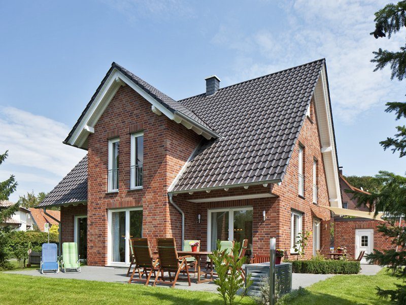 Haus Oswald - Ein großes Backsteingebäude mit Gras vor einem Haus - Haus