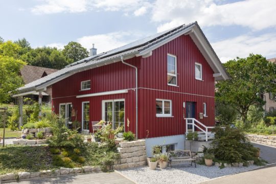 Haus Hälker - Ein Haus mit Büschen vor einem Backsteingebäude - SchwörerHaus KG Musterhaus Poing