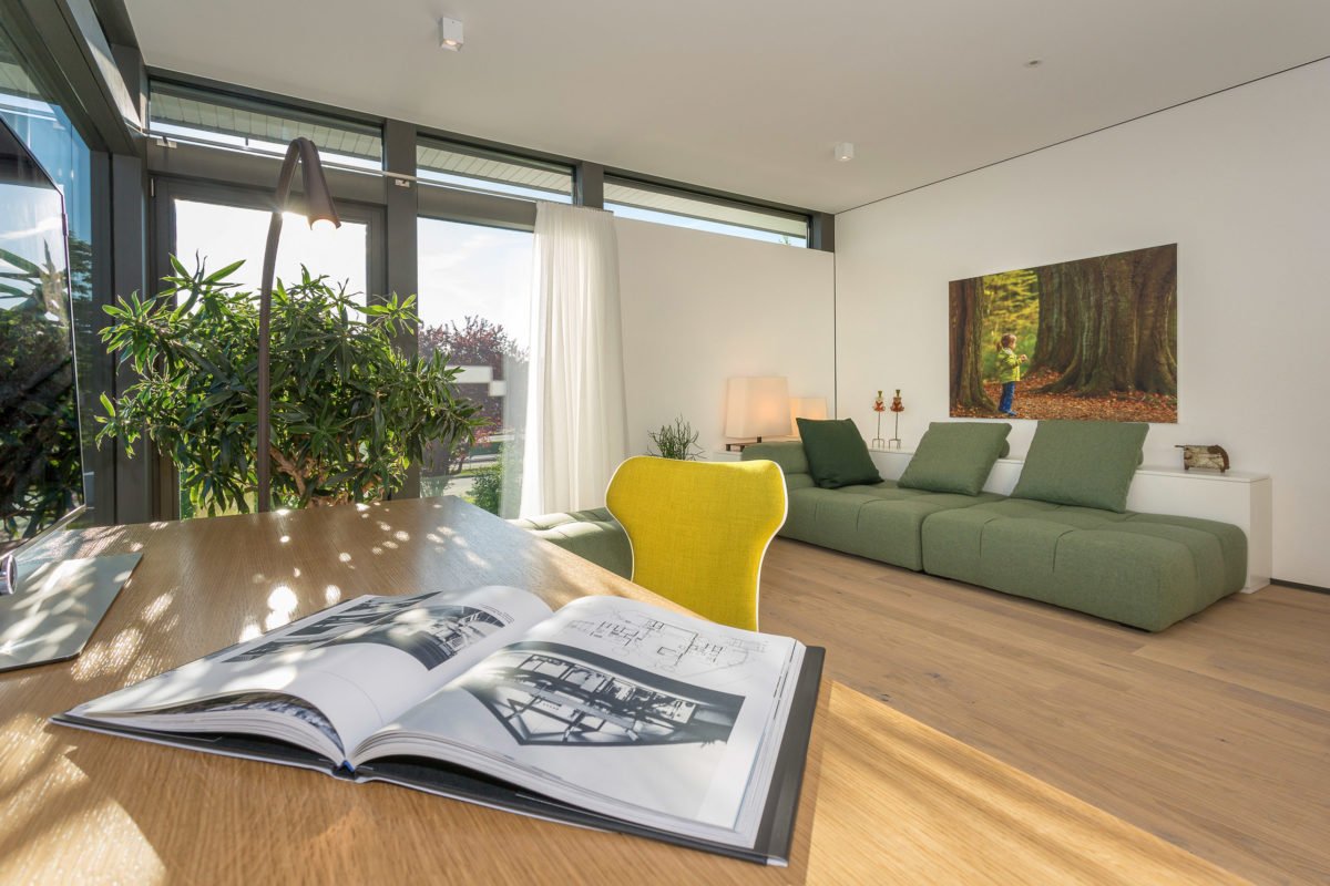 HUF HAUS Musterhaus Mannheim - Ein Wohnzimmer mit Möbeln und einem großen Fenster - Interior Design Services