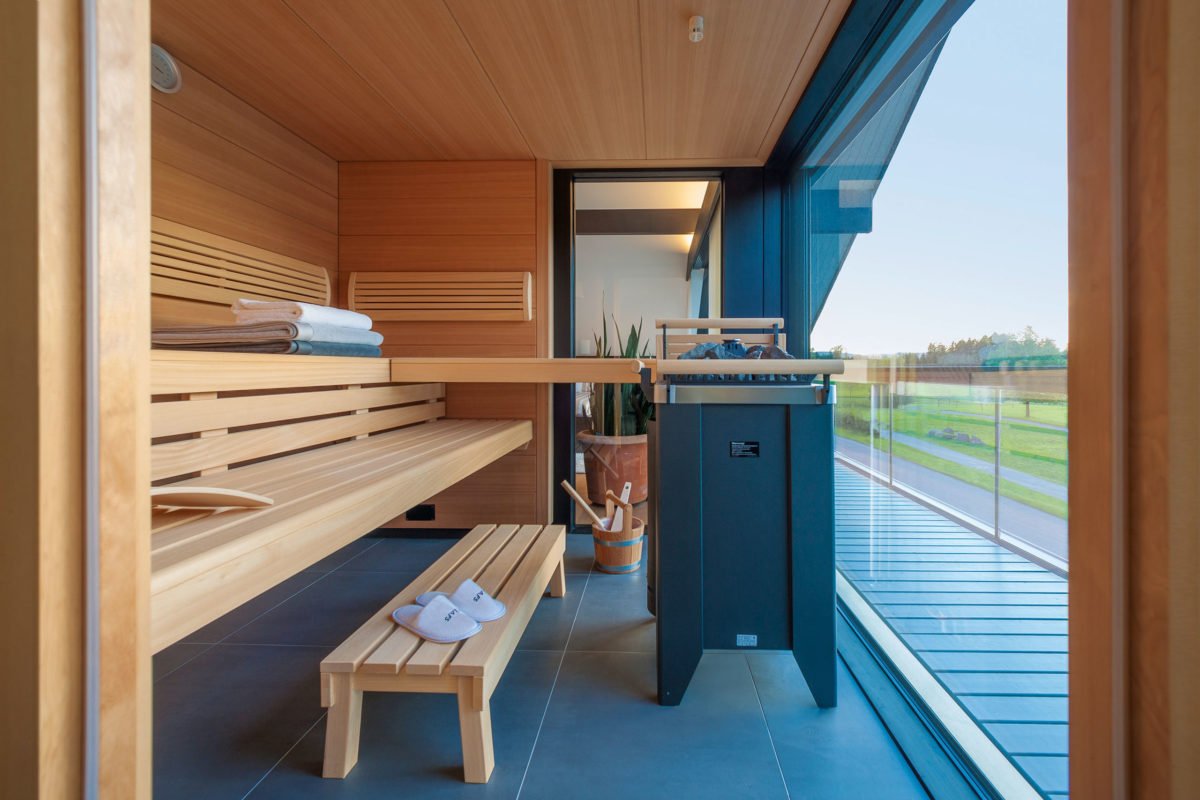 HUF HAUS Musterhaus Zürich - Eine Holzbank sitzt neben einem Fenster - Haus