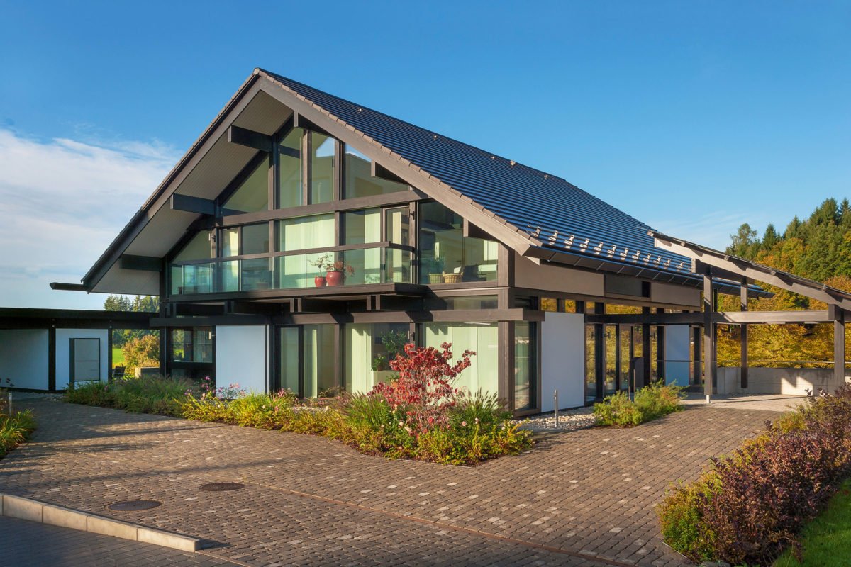 HUF HAUS Musterhaus Zürich - Ein Haus mit Bäumen im Hintergrund - Huf Haus