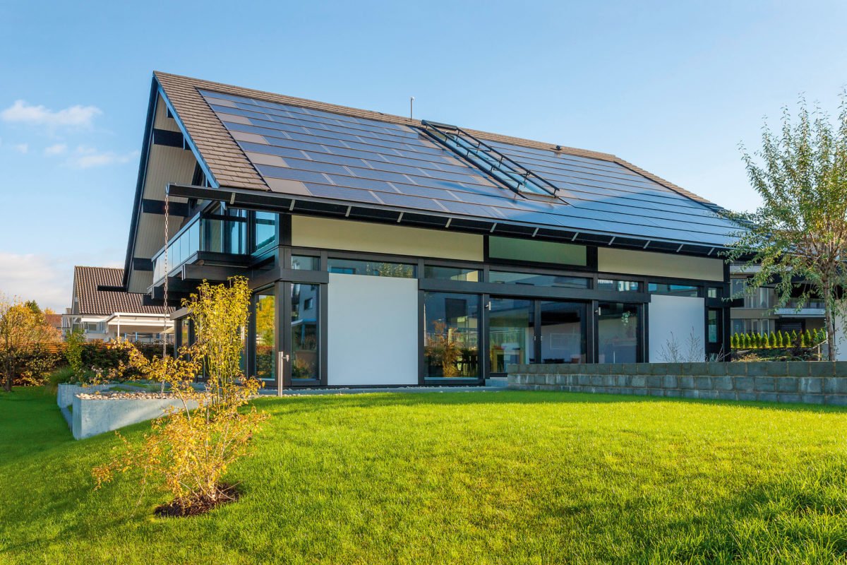 HUF HAUS Musterhaus Zürich - Eine gelbe Blume vor einem Haus mit Kiasma im Hintergrund - Huf Haus