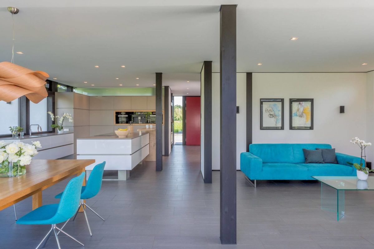 HUF Haus Modum 8 - Ein Wohnzimmer mit einem blauen Stuhl - Holzrahmen