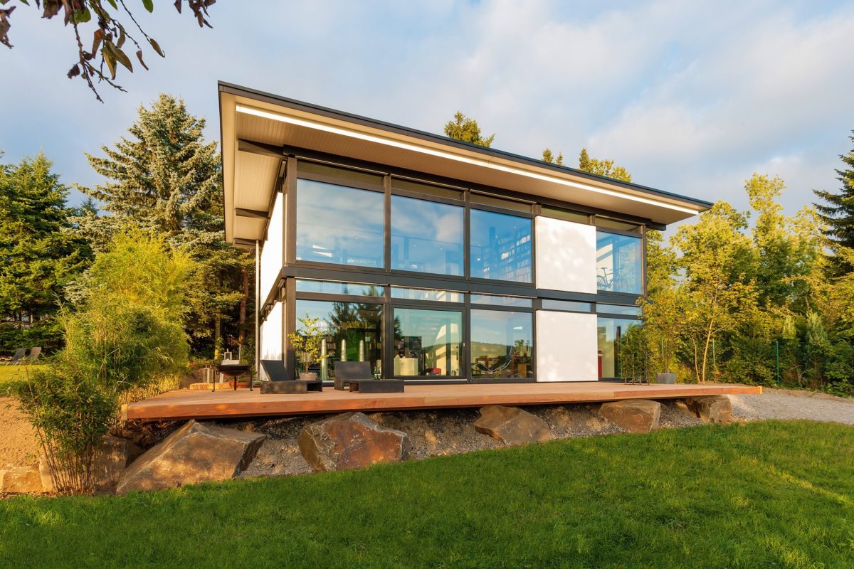 HUF Haus Modum 7 - Ein großes Backsteingebäude mit Gras vor einem Haus - Huf Haus