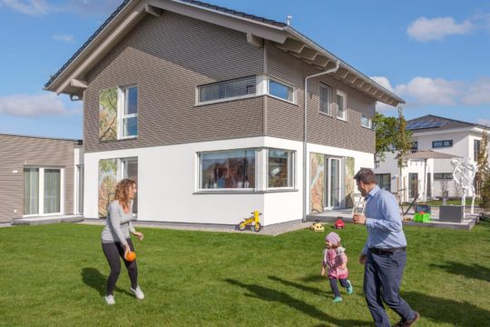 Musterhaus Günzburg - Eine Gruppe von Menschen, die Frisbee in einem Garten spielen - Haus