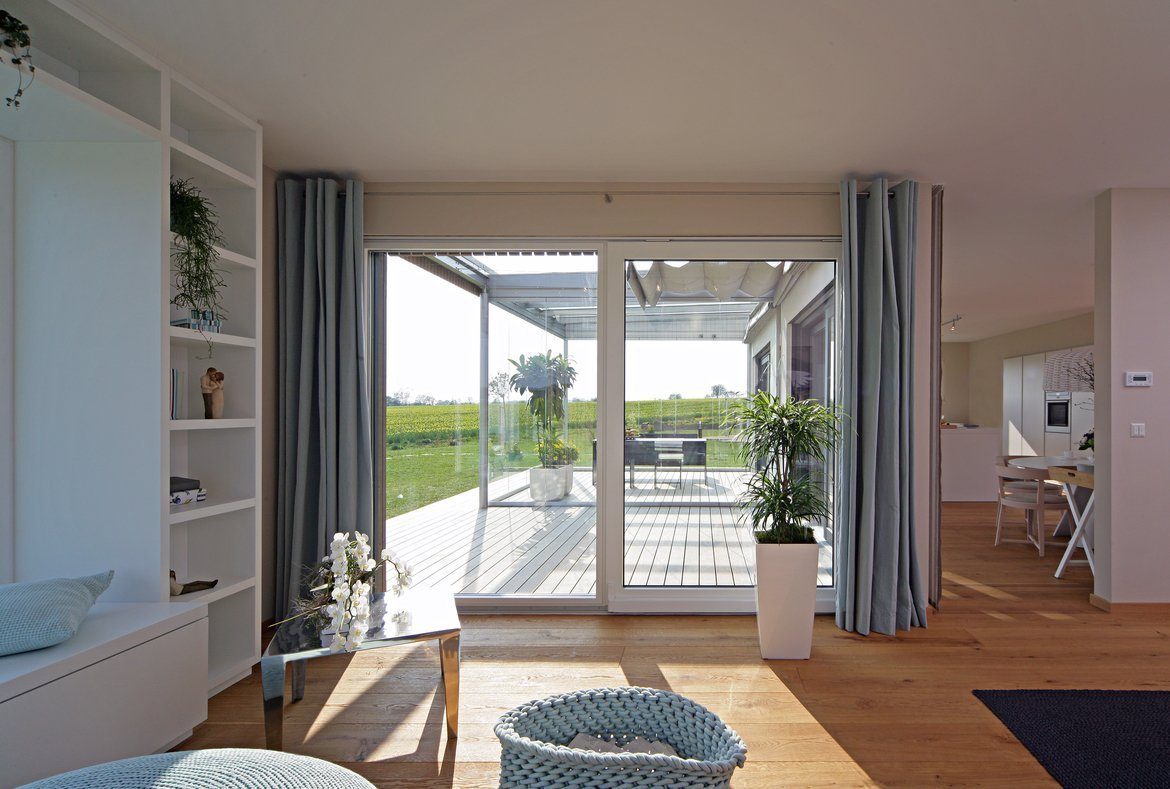 Brettheim - Ein Wohnzimmer mit Möbeln und einem großen Fenster - Haus