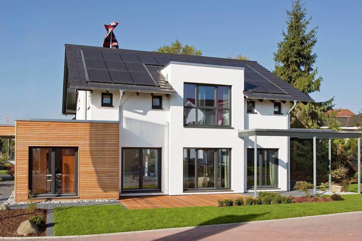 Musterhaus Wuppertal - Ein großes Backsteingebäude mit Gras vor einem Haus - Fertighaus