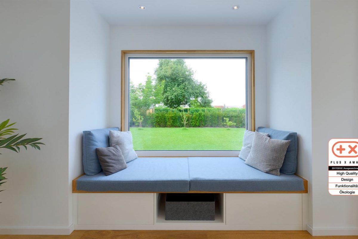 Musterhaus Life - Ein Wohnzimmer mit Möbeln und einem Flachbildfernseher - Fertighaus Weiss