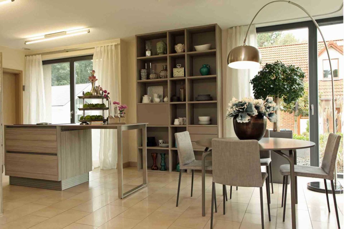 BRAVUR 550 – Musterhaus Bad Vilbel - Ein Wohnzimmer mit Möbeln und einem großen Fenster - FingerHaus