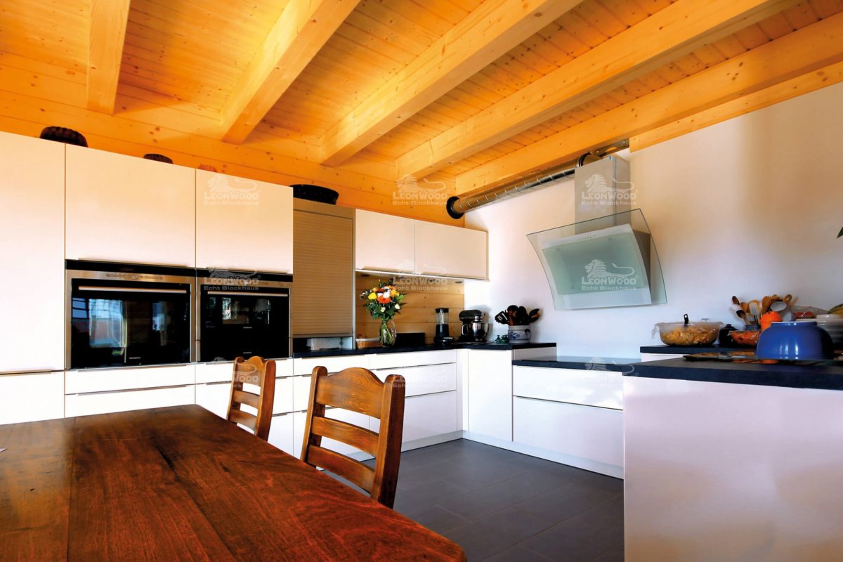 Villa Siena - Eine Küche mit einem Tisch in einem Raum - Holzhaus