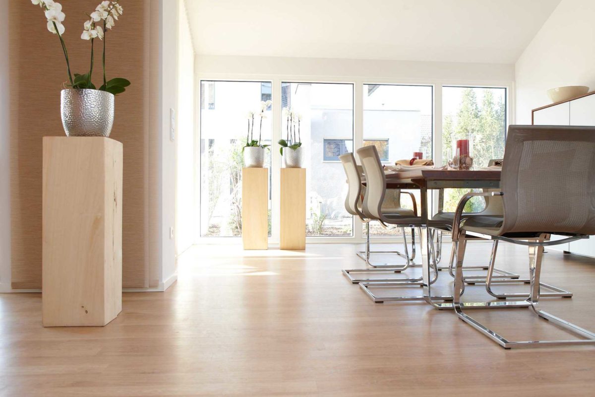 Musterhaus Mila - Ein Wohnzimmer mit Möbeln und Vase auf einem Tisch - Gussek Haus