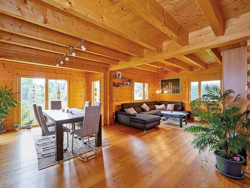 Haus Rosengarten - Ein Wohnzimmer mit Möbeln und einem großen Fenster - Rems-Murr-Holzhaus GmbH