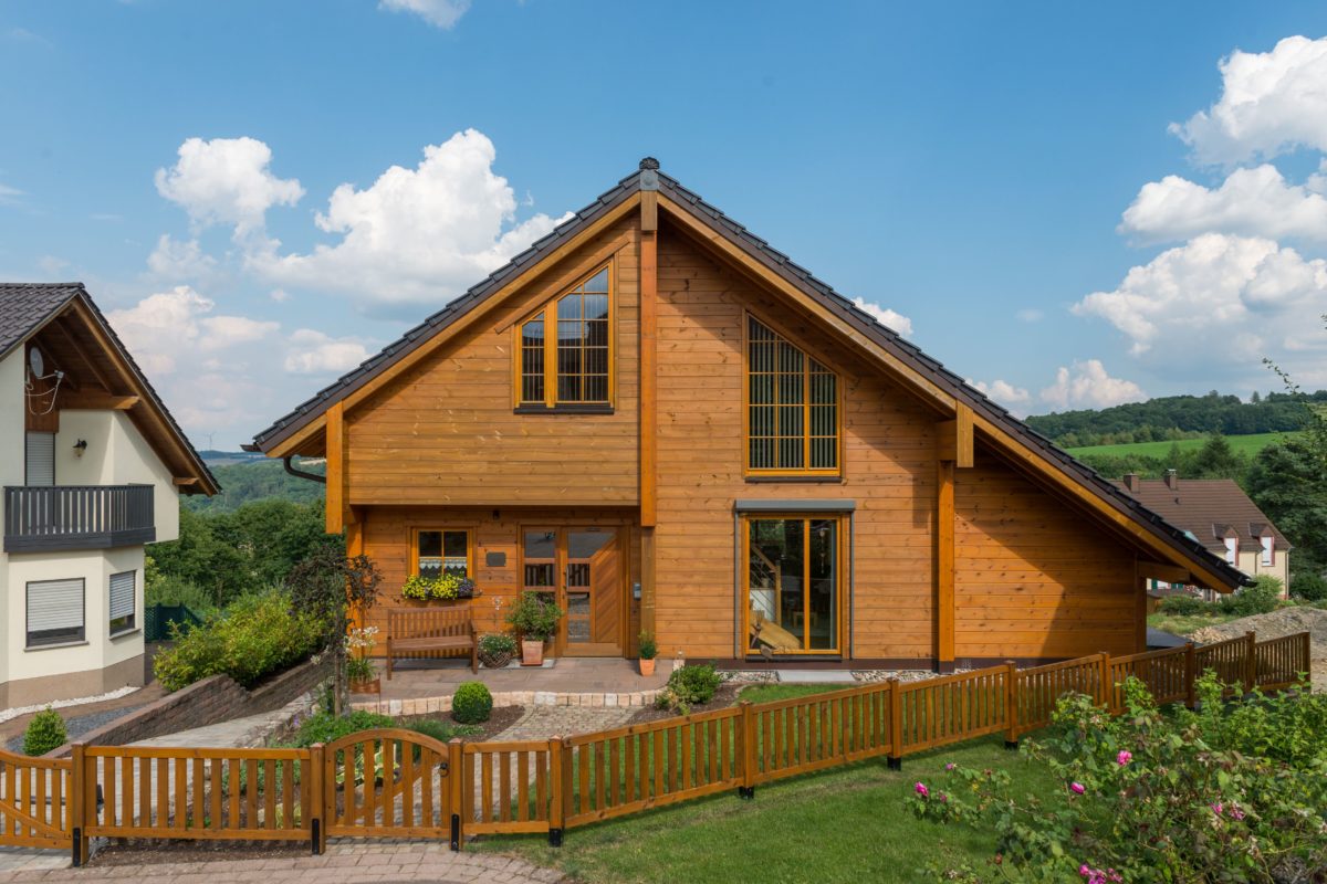 Musterhaus Dhrontalblick - Ein Haus mit einem Holzzaun - Fullwood Wohnblockhaus