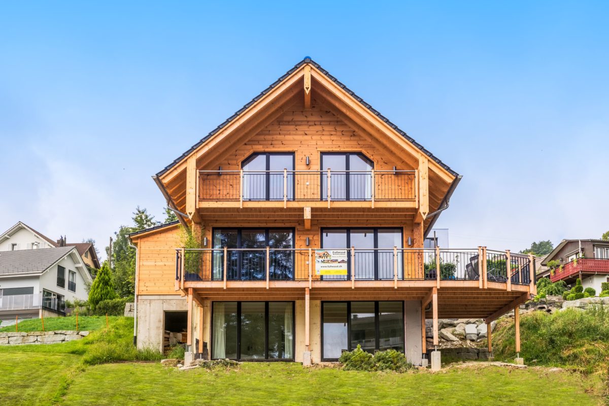 Holzhaus am Bächli - Ein kleiner Glockenturm vor einem Haus - f immobilien AG