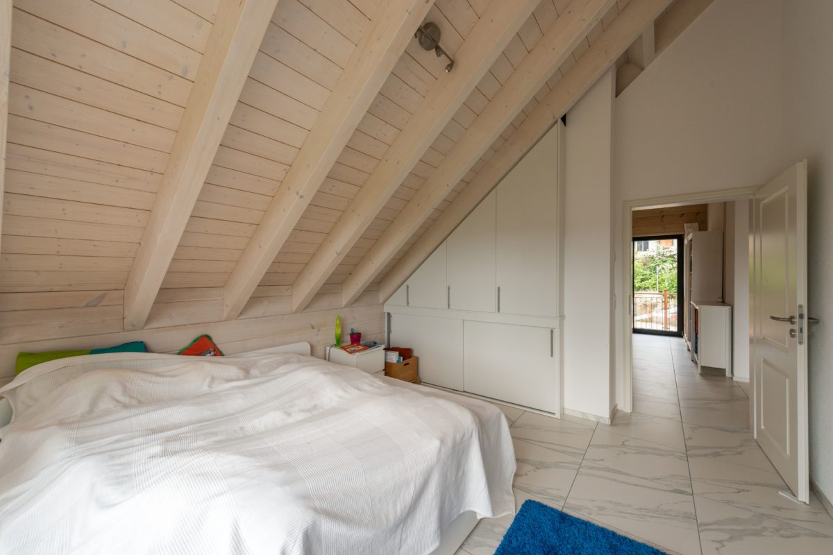 Holzhaus am Bächli - Ein Schlafzimmer mit einem Bett in einem Raum - Haus
