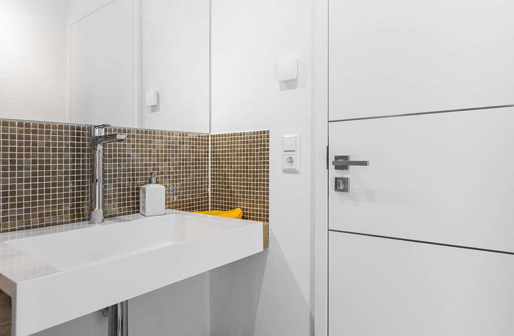 Musterhaus Bad Vilbel - Eine weiße Spüle sitzt unter einem Spiegel - Bad