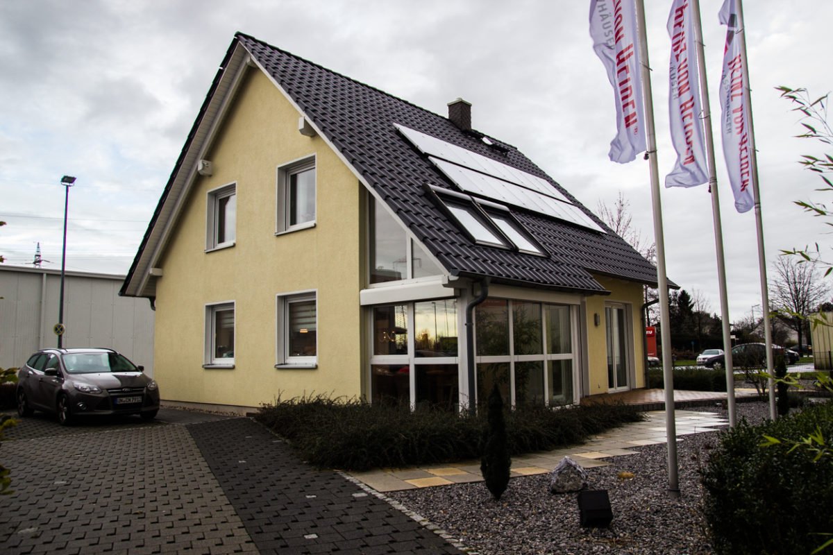 Musterhaus Kamen - Ein Haus, das an der Seite eines Gebäudes geparkt ist - Heinz von Heiden - Musterhaus Kamen