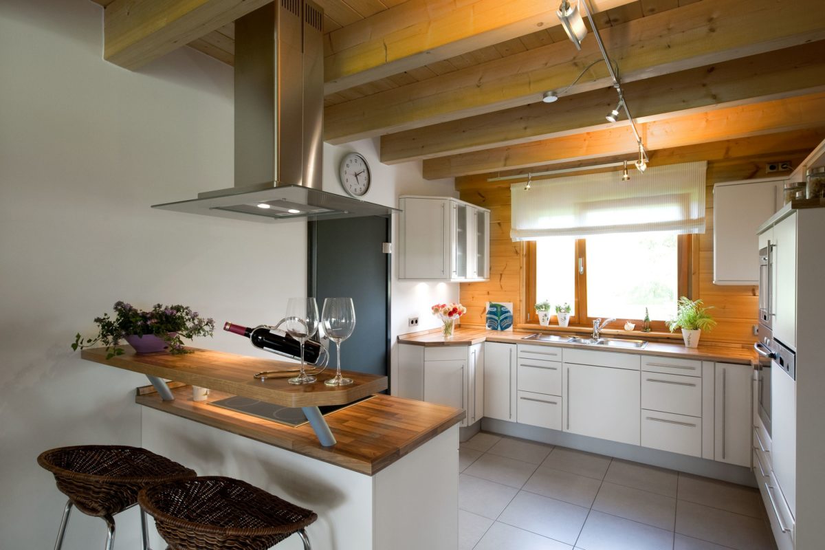 Holzhaus Barkhof - Eine Küche mit einem Tisch und in die Kamera schaut - Interior Design Services