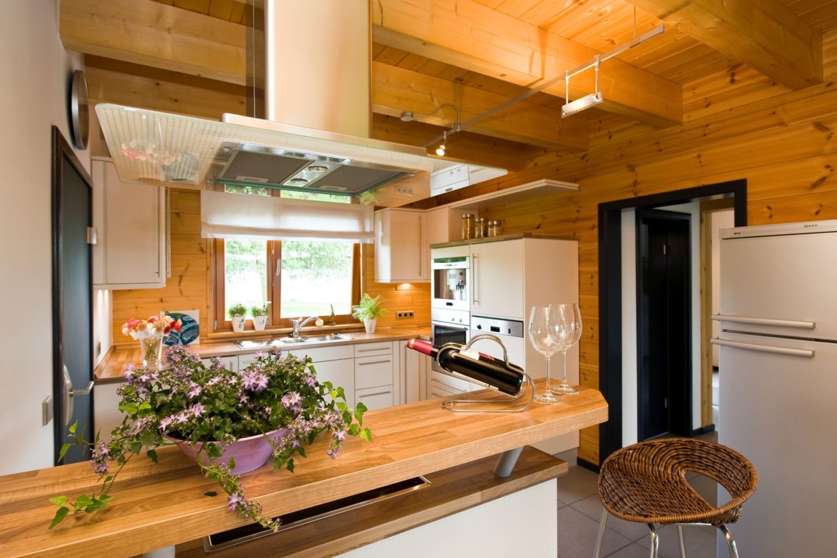 Holzhaus Barkhof - Eine Küche mit einem Tisch und in die Kamera schaut - Holzhaus