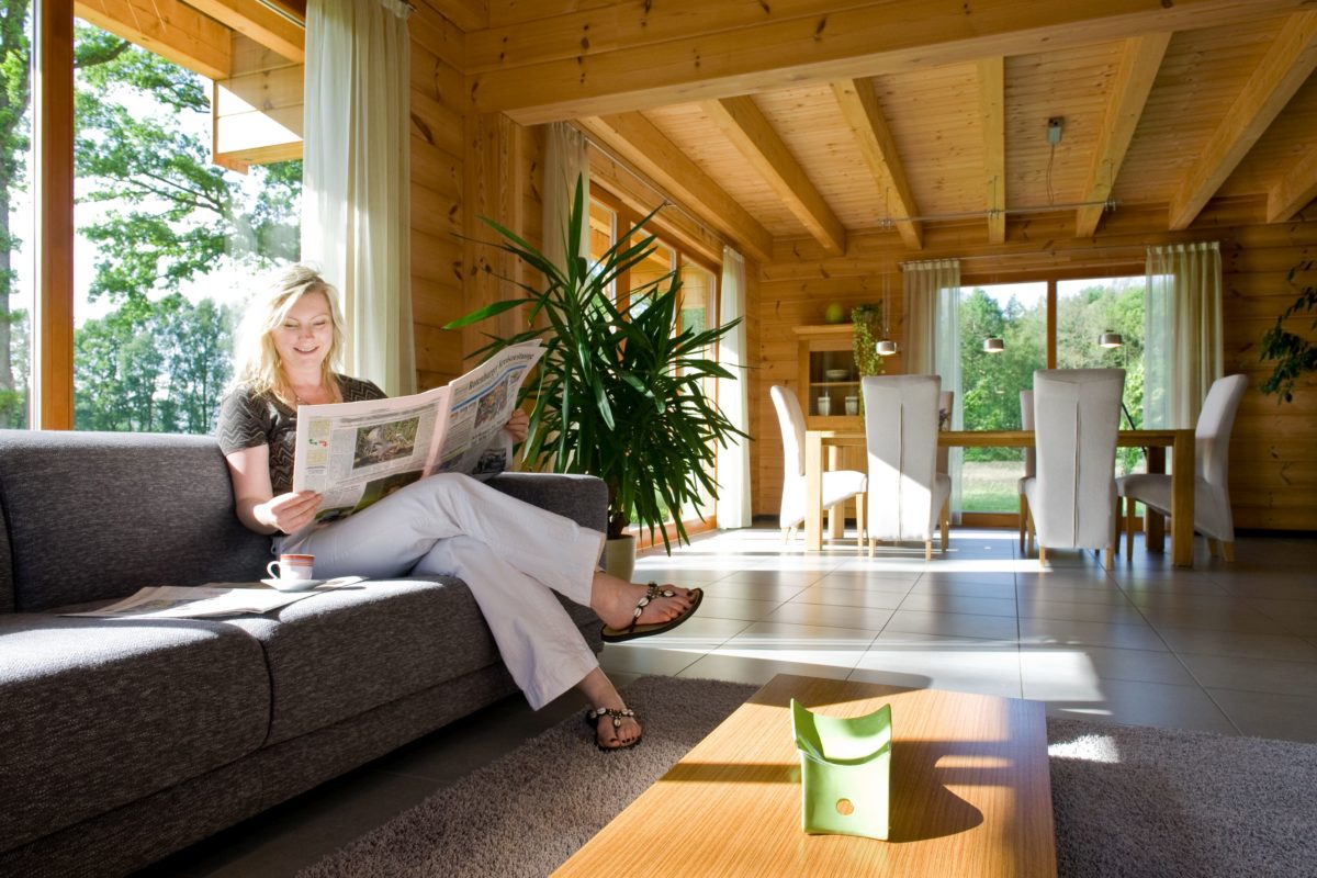 Holzhaus Barkhof - Eine Person, die in einem Wohnzimmer mit einem großen Fenster sitzt - Interior Design Services