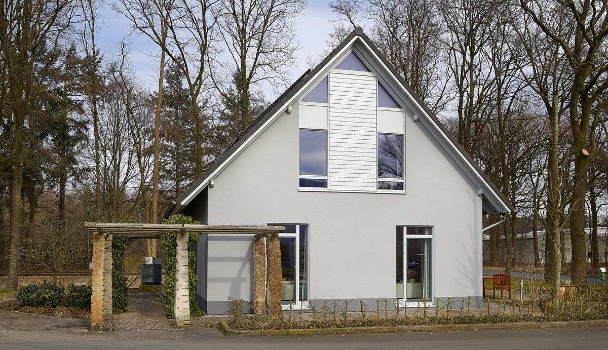 Musterhaus Svenja - Ein Haus mit Bäumen im Hintergrund - Fassade
