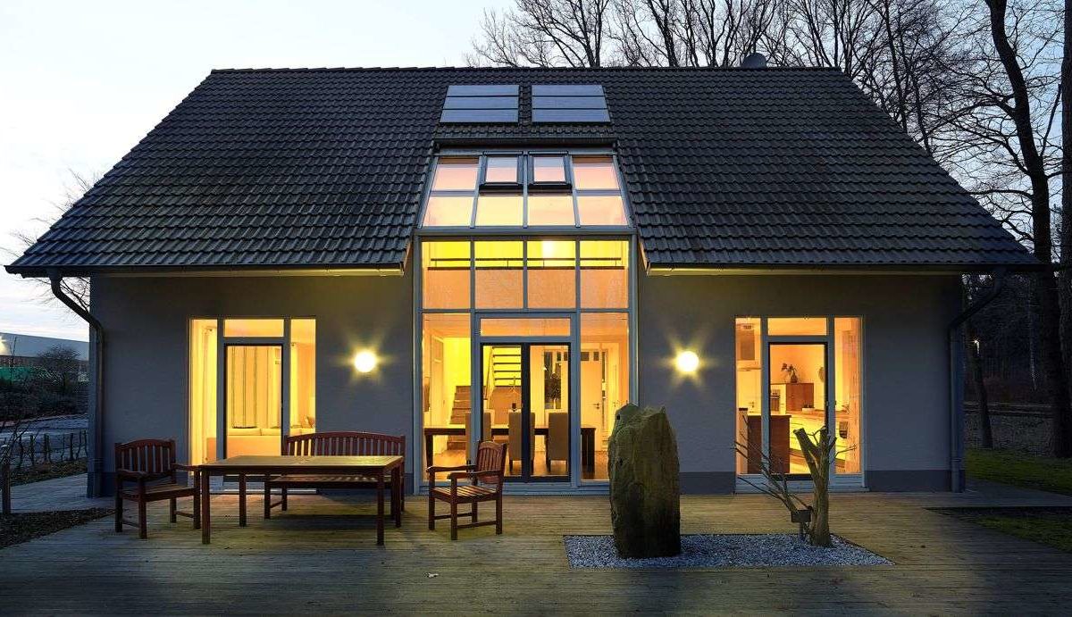 Musterhaus Svenja - Ein gelbes haus im hintergrund - Gussek Haus