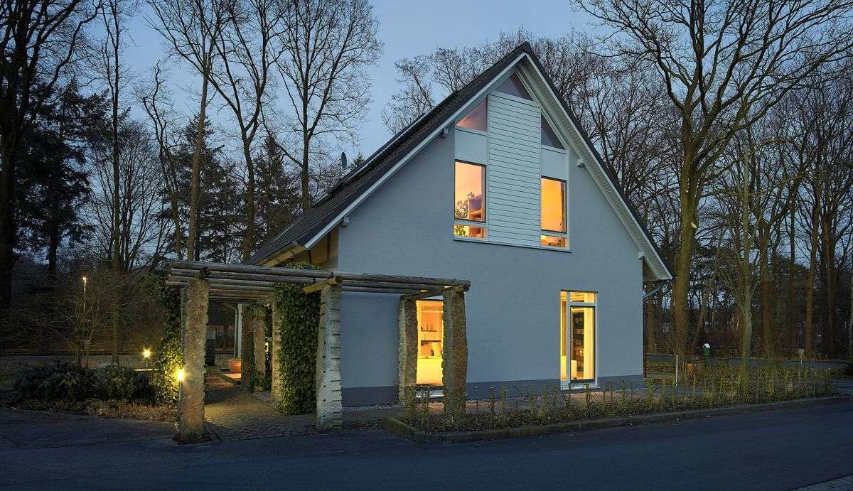 Musterhaus Svenja - Ein Haus mit Bäumen im Hintergrund - Haus