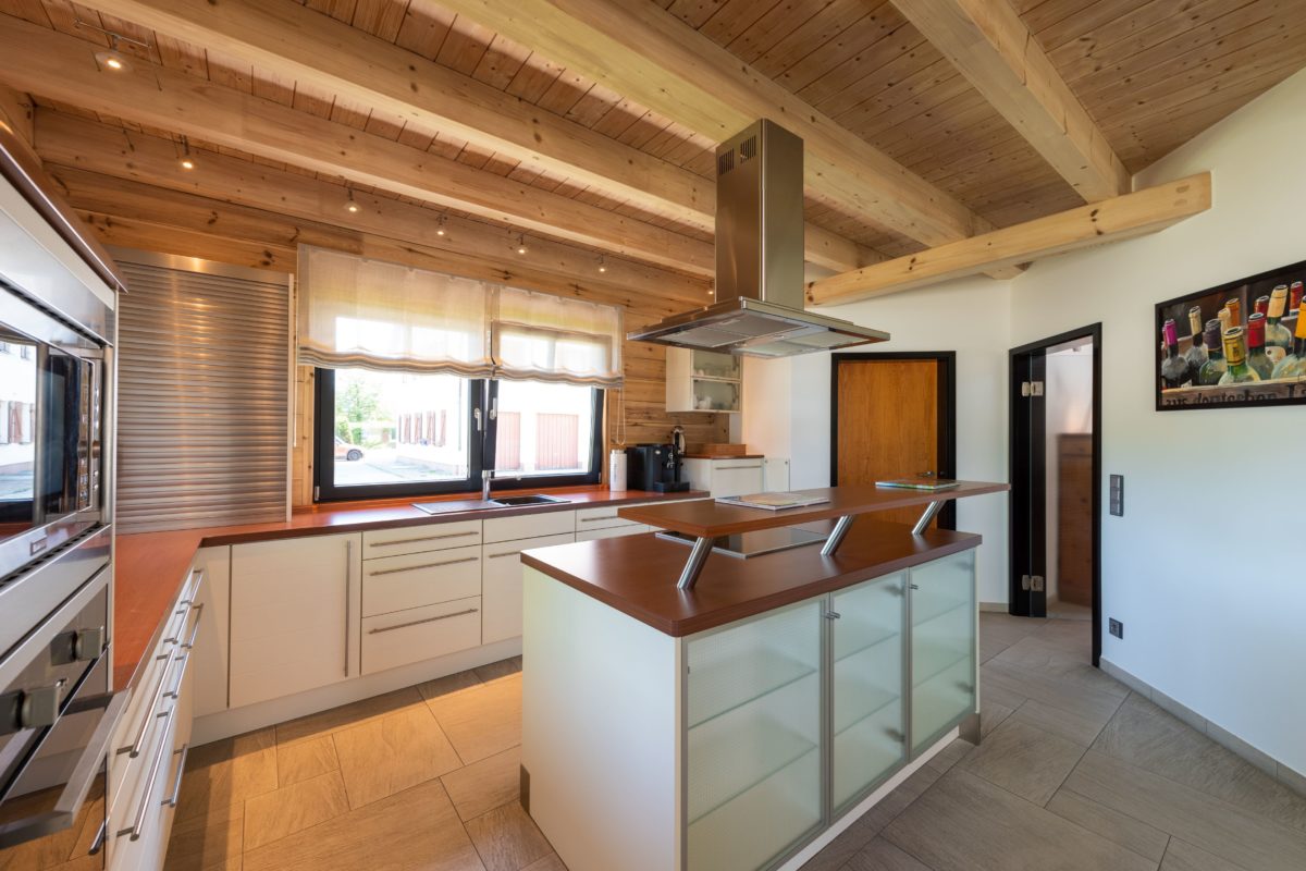 Musterhaus Hohenlohe - Eine küche mit waschbecken und fenster - Holzboden